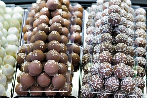 Int&eacute;rieur de chocolaterie artisanale avec pr&eacute;sentoir vitr&eacute; contenant des chocolats fins