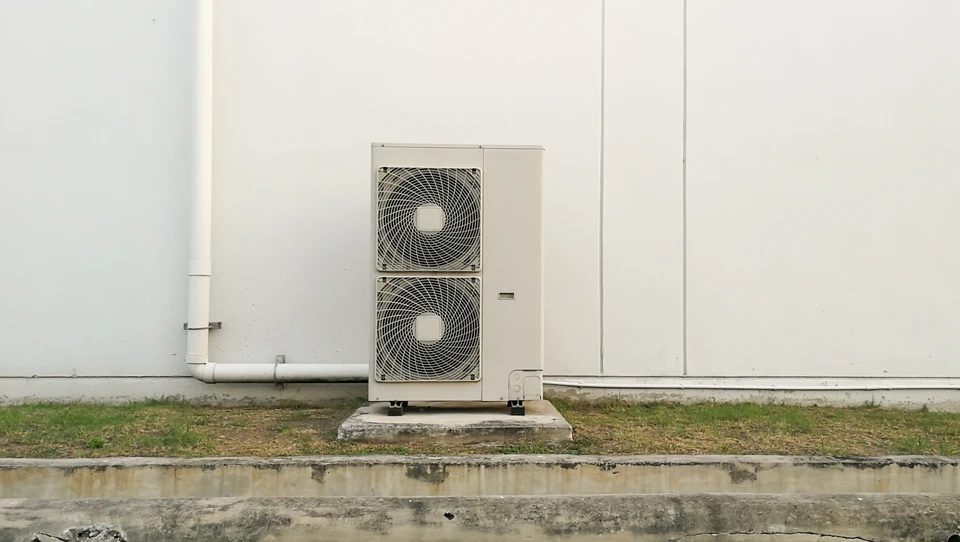 Extérieur d'un bâtiment commercial avec unité de climatisation posée sur dalle béton