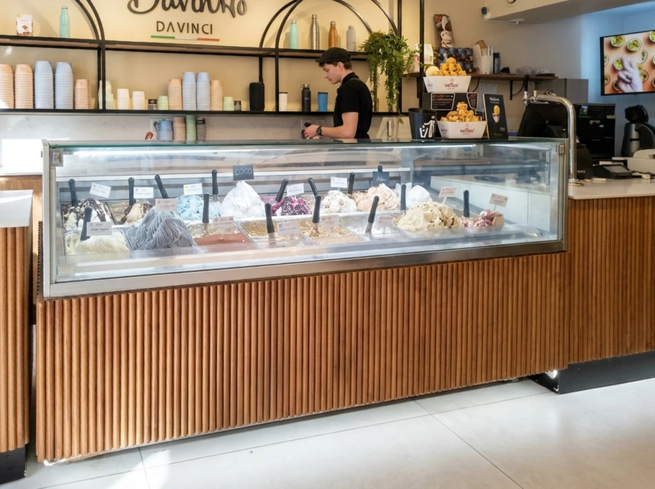 Comptoir de glacier avec vitrine réfrigérée présentant une douzaine de parfums de glaces artisanales