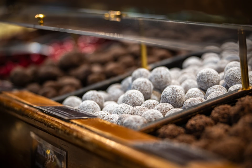 Intérieur de chocolaterie artisanale avec présentoir vitré contenant des chocolats fins