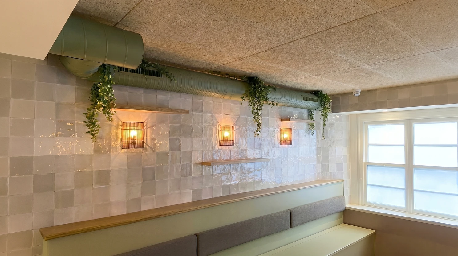 Int&eacute;rieur de restaurant moderne avec banquette murale grise